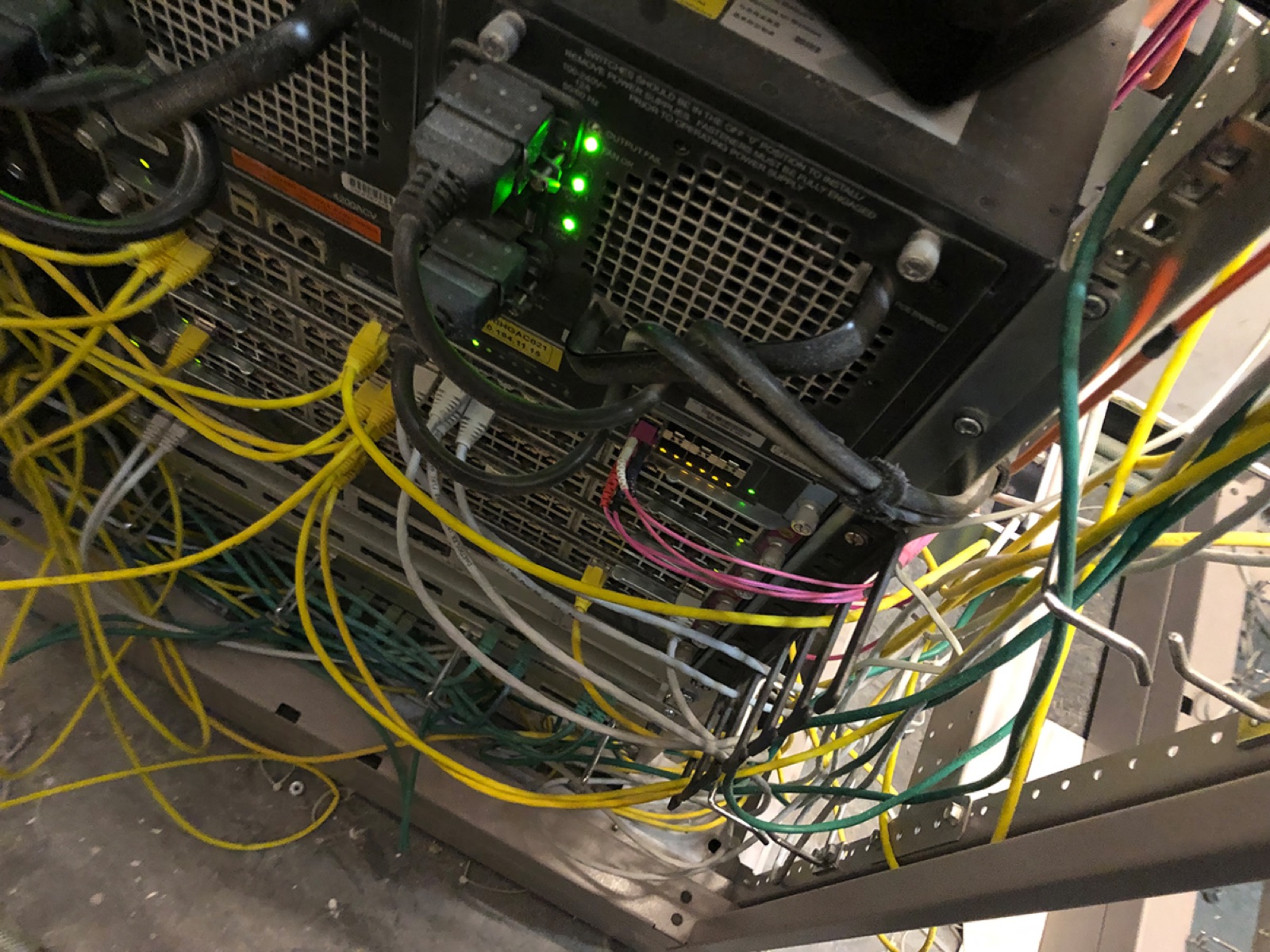 Verstaubter Etagenverteiler mit Netzwerkkabeln vor der technischen Reinigung durch rombus